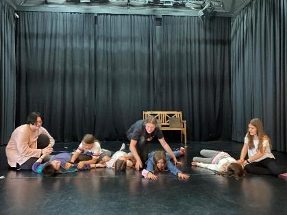 Mädchen* spielen Theater auf der Bühne.